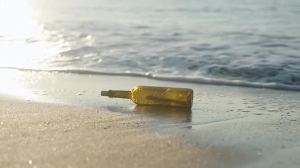 太阳升起了 一个装有便条的玻璃瓶被冲上了海滩 海浪把她推向岸上 — 图库视频影像