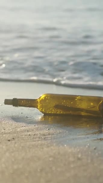 太阳升起了 一个装有便条的玻璃瓶被冲上了海滩 海浪把她推向岸上 垂直视频社交媒体 — 图库视频影像