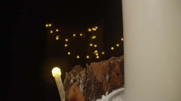 キャンドルは 暗闇のガーランドの背景に対する手作りの新年のインスタレーションで点灯されます ドリースライダー極端なクローズアップ — ストック動画