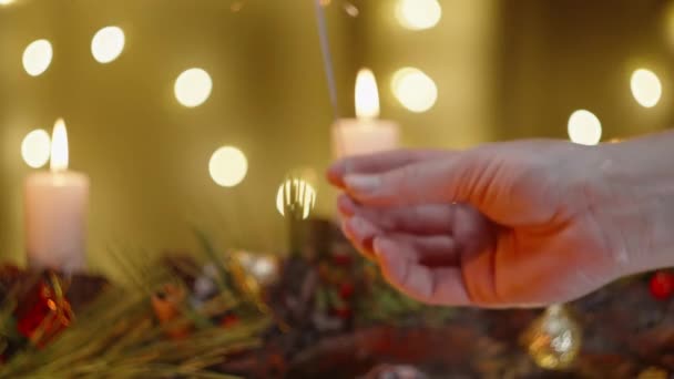 一只雌手从蜡烛上点燃了火花 照亮了圣诞装饰和家的内部 — 图库视频影像