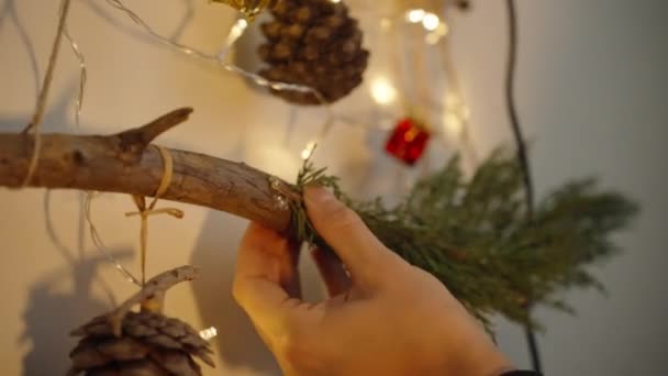 女性が新年の装飾を作り 熱い接着剤銃を使用して木の枝を接着しています — ストック動画