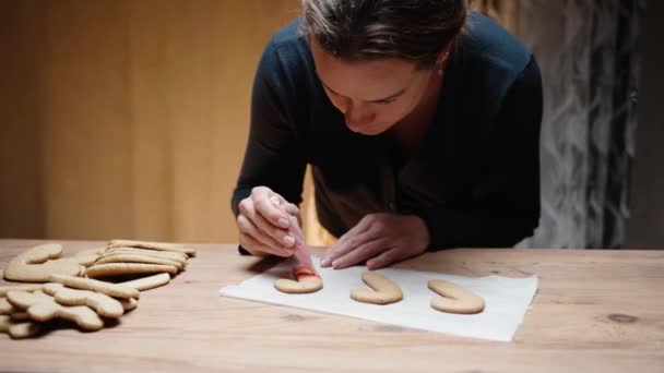 Die Junge Frau Verziert Lebkuchen Form Eines Zuckerrohrs Mit Rotem — Stockvideo