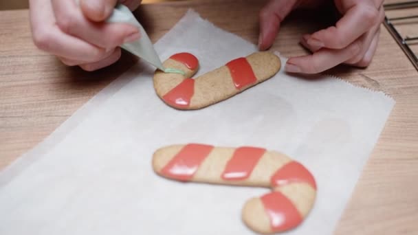 Woman Applying Green Icing Stripes Gingerbread Cookies Shaped Candy Canes — Stock Video