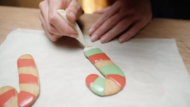 这位女士正在制作一种自制的圣诞姜饼糖果手杖 用五颜六色的糖霜填满它 — 图库视频影像