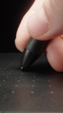 Siyah bir grafik tabletine yazıyorum. Dolly Slider aşırı yakın çekim. Laowa Sondası Dikey Video.