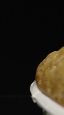 Kekin üzerine krema sıkıyorum, siyah arka planda. Dolly Slider aşırı yakın çekim. Laowa Sondası Dikey Video.