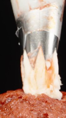 Kekin üzerine krema sıkıyorum, siyah arka planda. Dolly Slider aşırı yakın çekim. Laowa Sondası Dikey Video.