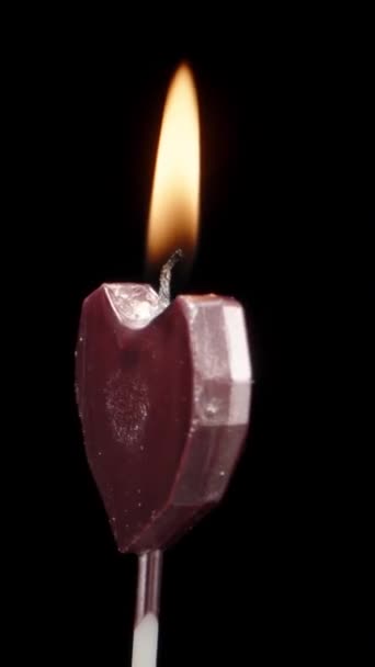 我把粉红的蜡烛吹灭在黑色的背景上 旋转着 垂直录像 — 图库视频影像