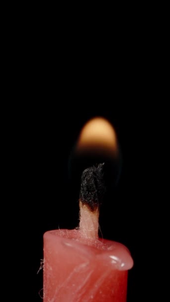 我在黑色的背景上点燃了一根红色的蜡烛 非常宏观 垂直录像 — 图库视频影像