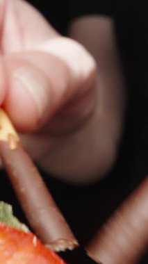 Çikolata parçalı kurabiye çubuğunu kırdım ve bir kekin üzerindeki kremanın içine koydum. Dolly Slider aşırı yakın çekim. Laowa Sondası Dikey Video.