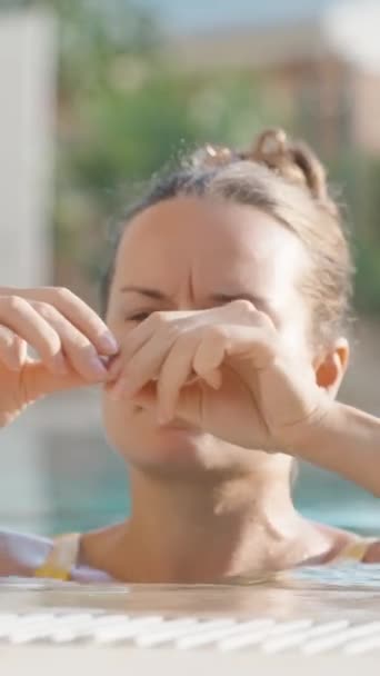 游泳池里的一位年轻女子戴上蓝色鼻衣别针 夏天和外面的阳光垂直 社交媒体 — 图库视频影像