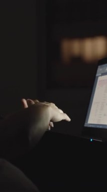 Gece, genç bir kadın dizüstü bilgisayarla yatakta. Dikey, sosyal medya..