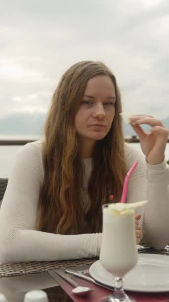 一位年轻女子在海边山上的一家餐馆里喝着鸡尾酒 垂直视频社交媒体 — 图库视频影像