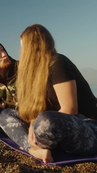 一对年轻夫妇在海滨遇见了日出 然后鬼鬼祟祟地亲吻着 垂直视频社交媒体 — 图库视频影像
