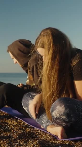 一对年轻夫妇在海滨遇见了日出 一个女孩把鹅卵石送给了一个男人 他把鹅卵石扔进了海里 垂直视频社交媒体 — 图库视频影像