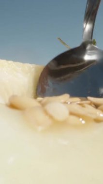 Yarım karpuz, içindeki tohumları kaşıkla topla. Güneş, mavi gökyüzü. Dikey, Sosyal Ortam