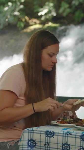 Молодая Женщина Кафе Воде Намазывает Масло Лепешки Откусывает Большим Аппетитом — стоковое видео