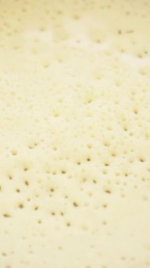 Genç bir kadın krep pişiriyor. Yakın plan. Krepi ahşap bir spatulayla çevirir. Dikey. Sosyal Medya