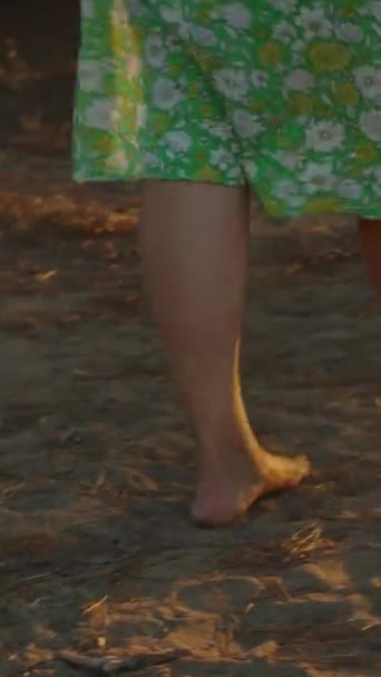 Μια Νεαρή Γυναίκα Ένα Πράσινο Φόρεμα Λουλούδια Περπατώντας Προς Ηλιοβασίλεμα — Αρχείο Βίντεο