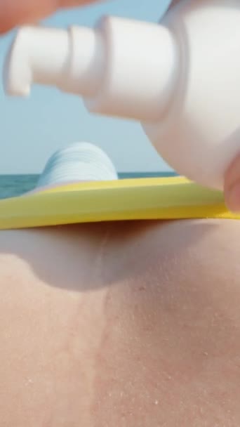 노란색 수영복을 여성은 가슴에 선스크린을 적용합니다 경치와 수직이에요 미디어 — 비디오