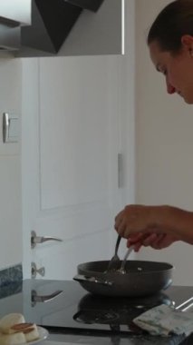 Yemek pişirmek. Peynirli krepleri tavadan çıkarıp bir tabağa koyuyorum. Pencerede güneş ışığı var. Dikey. Sosyal Medya