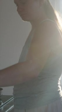 Yemek pişirmek. Peynirli krepleri tavadan çıkarıp bir tabağa koyuyorum. Pencerede güneş ışığı var. Dikey. Sosyal Medya