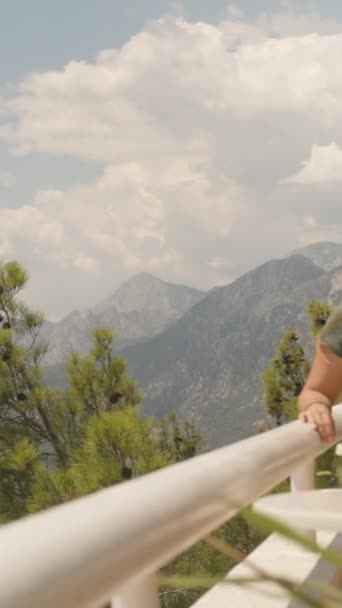 선글라스를 여자는 아이스 커피를 마신다 그녀의 뒤에는 산들이 있습니다 수직이에요 — 비디오