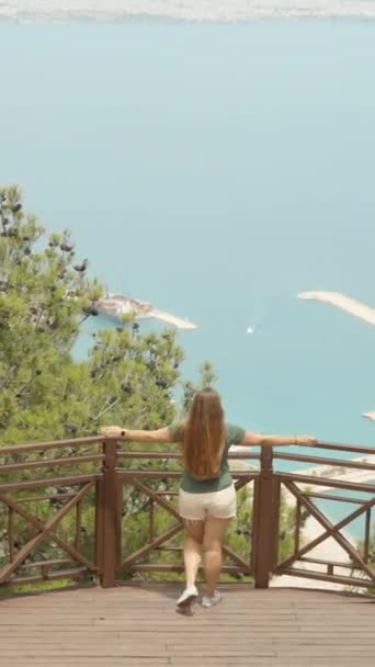 一个留长发的年轻女子走近栏杆 从高山上看海景 垂直的 社交媒体 — 图库视频影像