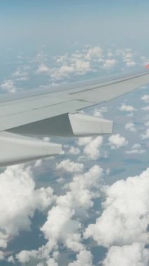 Uçağın kanadı bulutlarda. Uçak dönüyor. Dikey video.