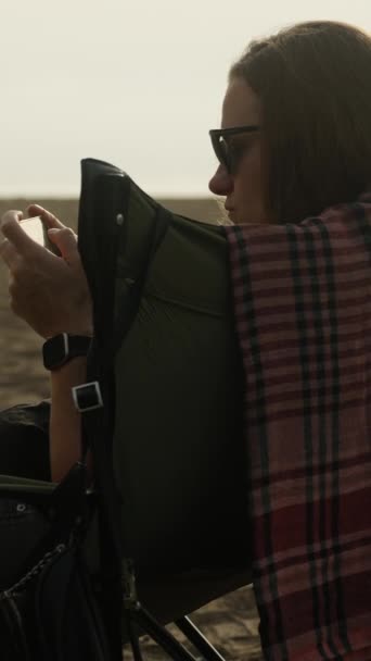 Młoda Kobieta Siedzi Krześle Nad Morzem Bawi Się Przez Telefon — Wideo stockowe
