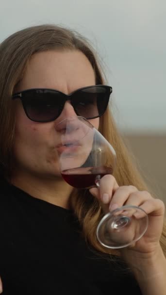여자는 바다에 해변에 의자에 유리에서 와인을 마시는 비디오 미디어 — 비디오