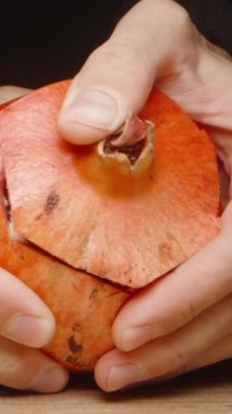 Nar meyvesini temizliyorum. Önünü kesip kapağını açtım. Siyah bir arka planda. Yavaş çekim Dikey video Sosyal Ortamı