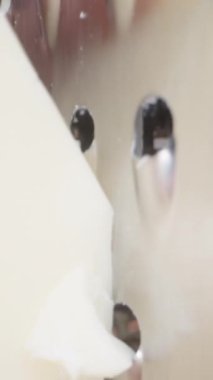 Genç kadın metal rendesine peynir sürüyor, kamera onu takip ediyor, aşırı makro. Dikey video Sosyal Ortamı