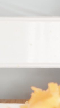 Havuçlar öğütücüye sıkışıyor, havuçlar kameraya dökülüyor. Dolly Slider, çok yakın çekim. Dikey video Sosyal Ortamı