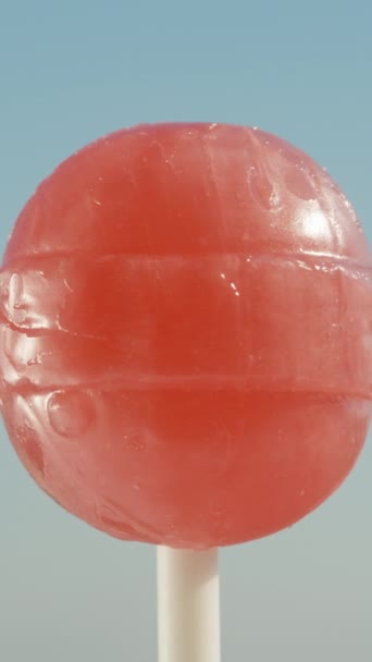 一颗红色圆圆的棒棒糖 在天空中旋转着 垂直视频社交媒体 — 图库视频影像