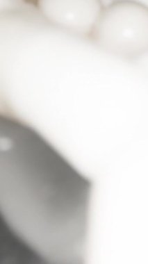 Hapları, beyaz kapsülleri elime döküyorum. Siyah arka plandaki siyah bir kavanozdan. Dolly Slider aşırı yakın çekim. Dikey video Sosyal Ortamı