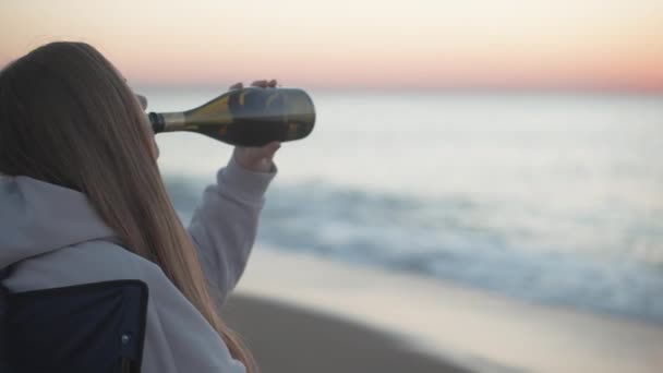 Yalnız Genç Bir Kadın Şişeden Şampanya Içer Deniz Kenarındaki Sandalyede — Stok video