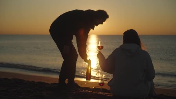 커플은 와인과 바다에서 낭만적 일출을 만난다 남자는 망치고 무늬에 뜨린다 — 비디오