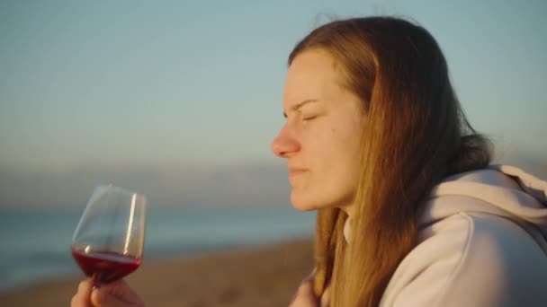 海の日の出 孤独な若い女性はワインのグラス全体を飲み クローズアップ — ストック動画