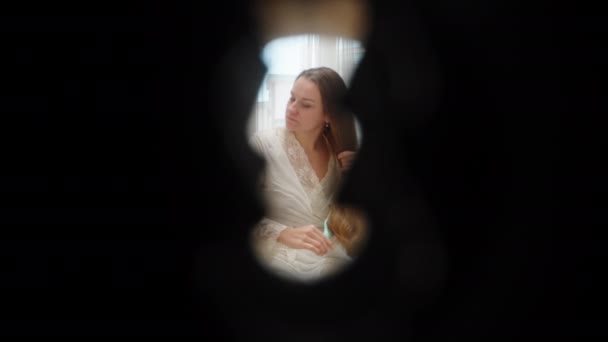 침대에 앉아있는 여자가 그녀의 머리를 빗질로 키홀을 익스트림 매크로 — 비디오