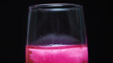 Şampanya bardağına pembe pamuk şeker atıyorum ve köpüklerle pembeye dönüyor, yakın plan..