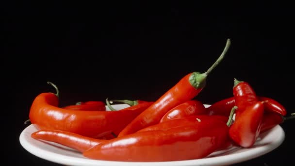 Röd Chili Paprika Vit Platta Närbild Roterande Svart Bakgrund — Stockvideo