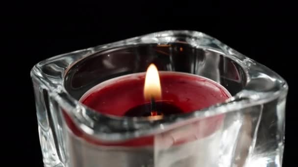 Una Vela Roja Candelero Vidrio Gira Arde Sobre Fondo Negro — Vídeo de stock