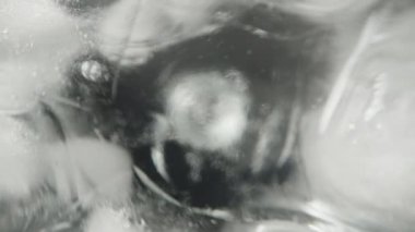 Buz küpleri bir bardakta erir. Sodayla, kaydırağın üstünde, makroyla..