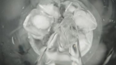 Buzlu bir bardağa soda dolduruyorum. Üst görünüm, makro slayt