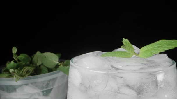 ミントの容器とテーブルの上のソーダのグラス ミントは氷の上に残る ドリースライダー極端なクローズアップ — ストック動画