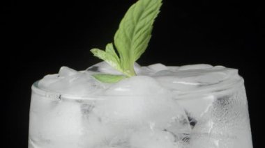 Soda ve buz dolu soğuk bir bardak, içine nane yaprağı atıyorum. Yakın plan. Tazeleyici içecek..