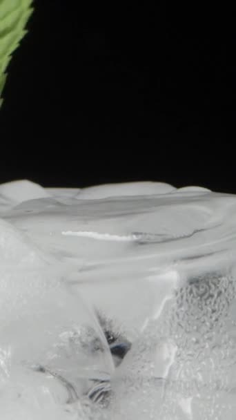 ソーダと氷のキューブが付いている涼しいガラス 私はそれにミントの葉を投げます クローズアップ リフレッシュドリンク 垂直ビデオ ソーシャルメディア — ストック動画