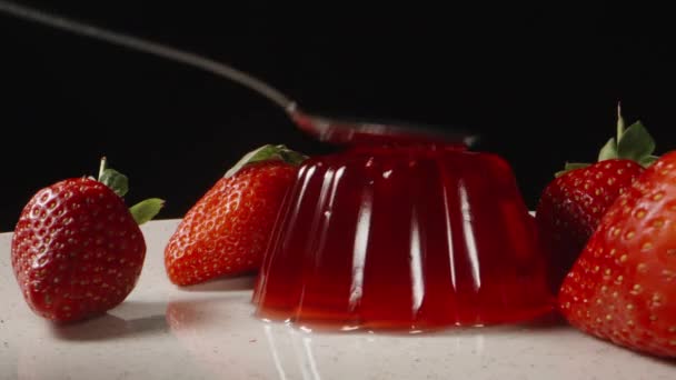 红果冻 盘中放草莓 我用勺子敲它 它扭动着 — 图库视频影像