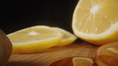 Tahta bir masada limon ve bal dilimlenmiş zencefil kökü. Dökülmüş bal. Dolly Slider aşırı yakın plan. .